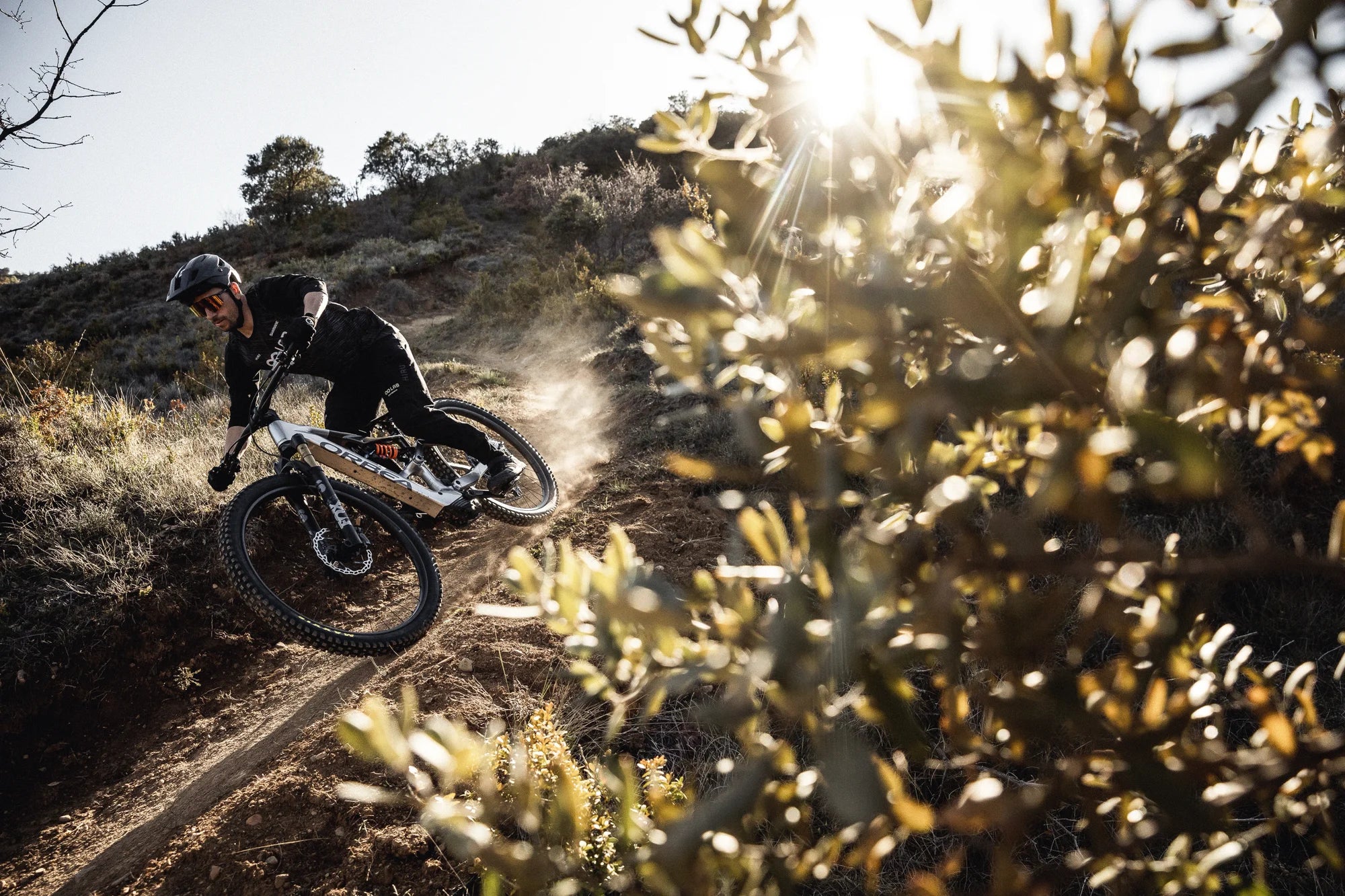 man going downhill on an orbea rise mountain bike