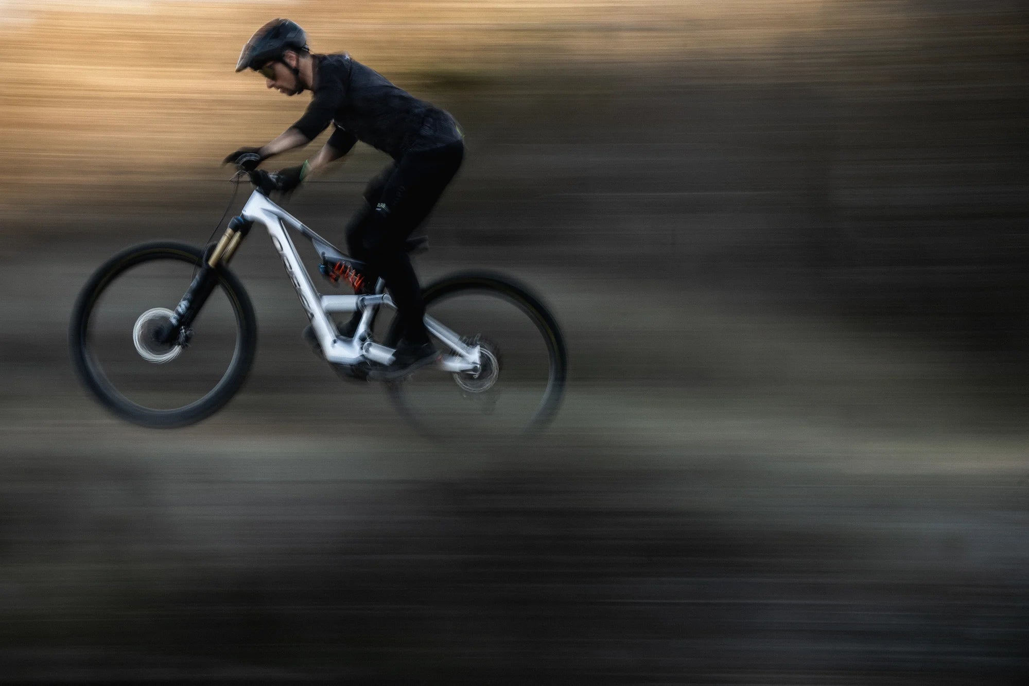 man riding an orbea rise mountain bike at speed