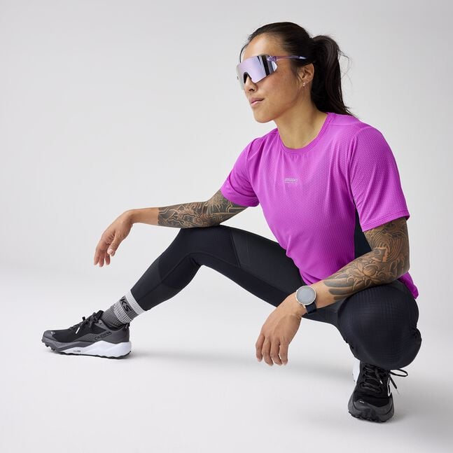 Woman wearing brooks high point short sleeve 2.0 running shirt purple with brooks branding
