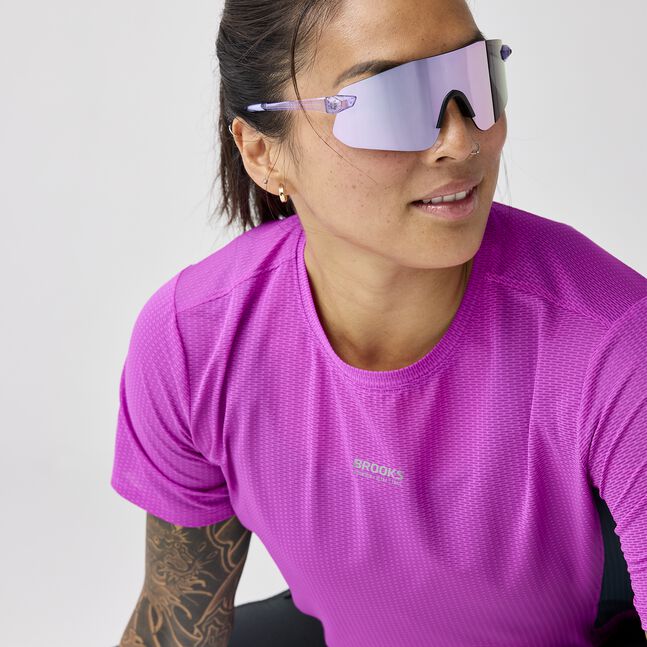 Woman wearing brooks high point short sleeve 2.0 running shirt purple with brooks branding