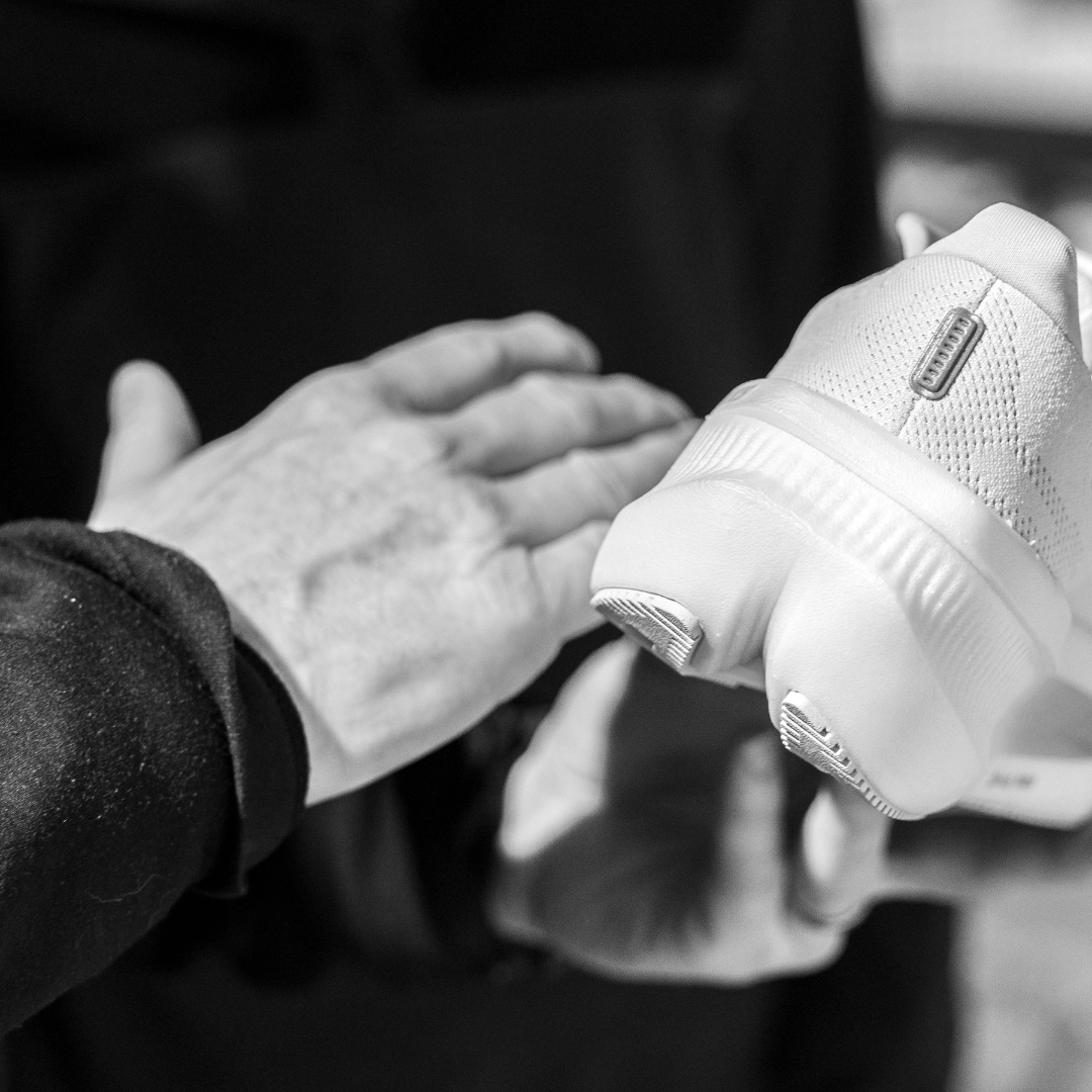 Member of The Sports Room team explaining the details of a run shoe to a customer