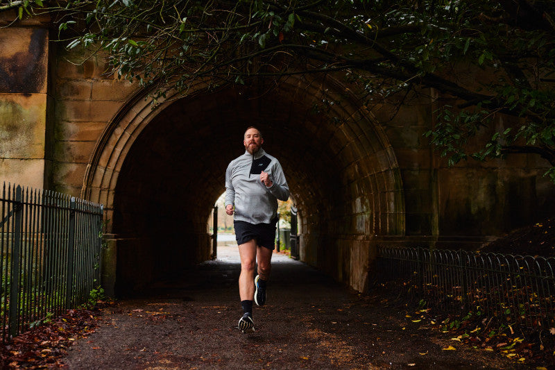 Man running in New Balance Long Sleeve Quarter Zip Top