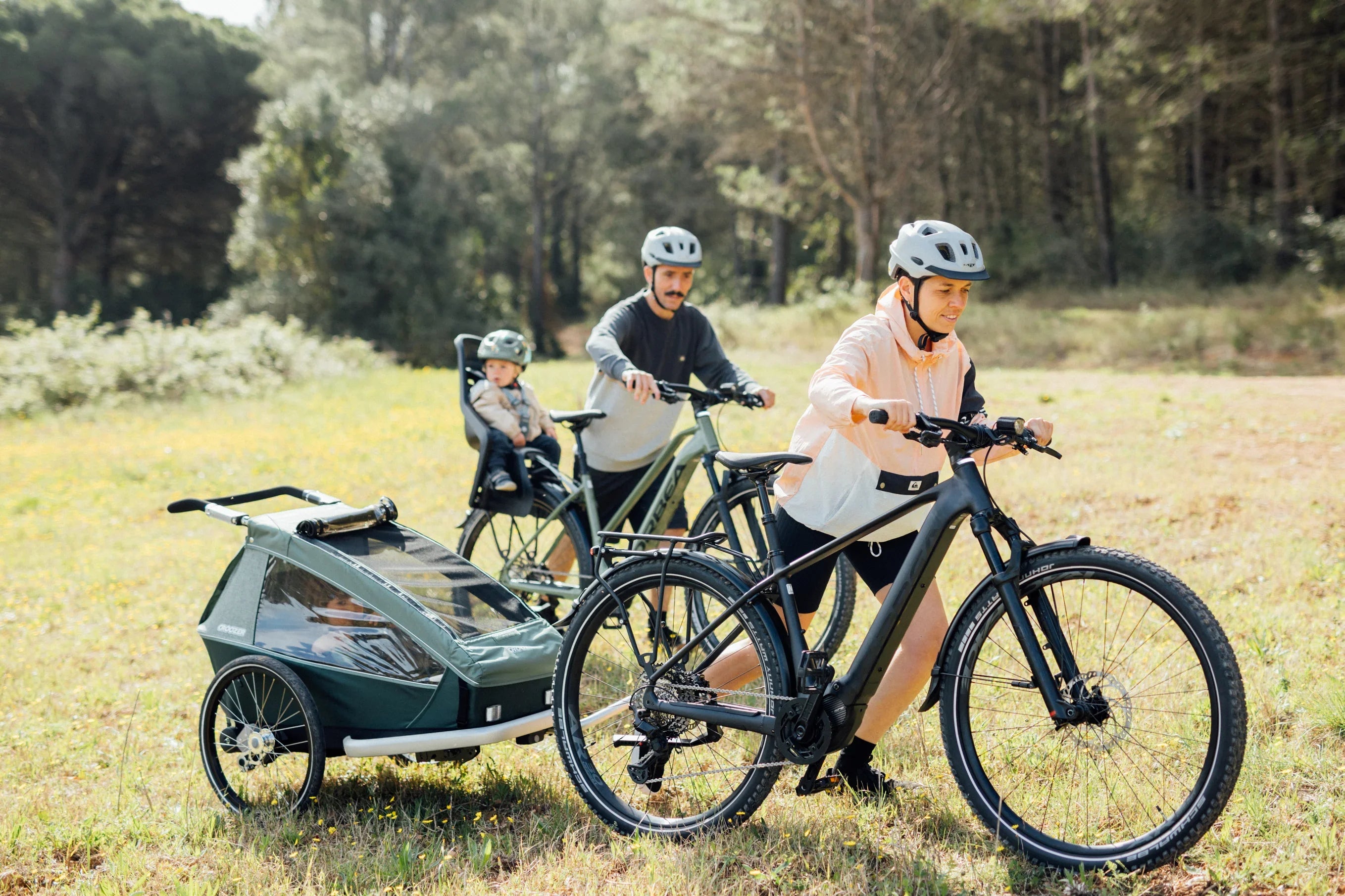family cycling on orbea electric bike, pulling baby trailer, with child seat, kemen ebike