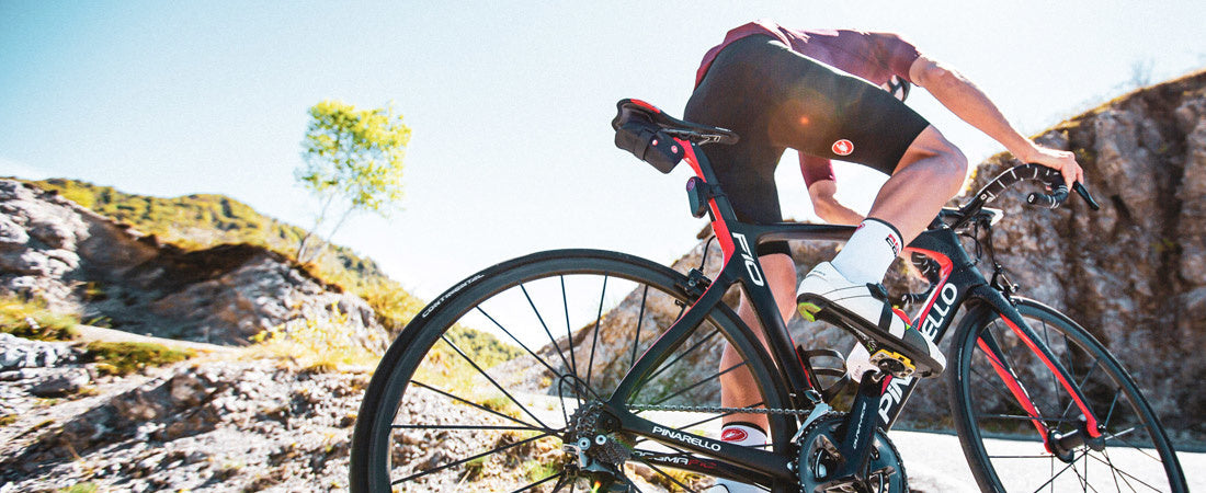 man road cycling up mountain pass wearing castelli shorts and bibtights
