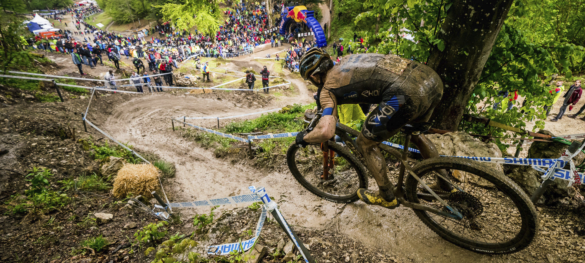 mountain biker on a versatile hardtail mountain bike, mtb, heading down a muddy trail
