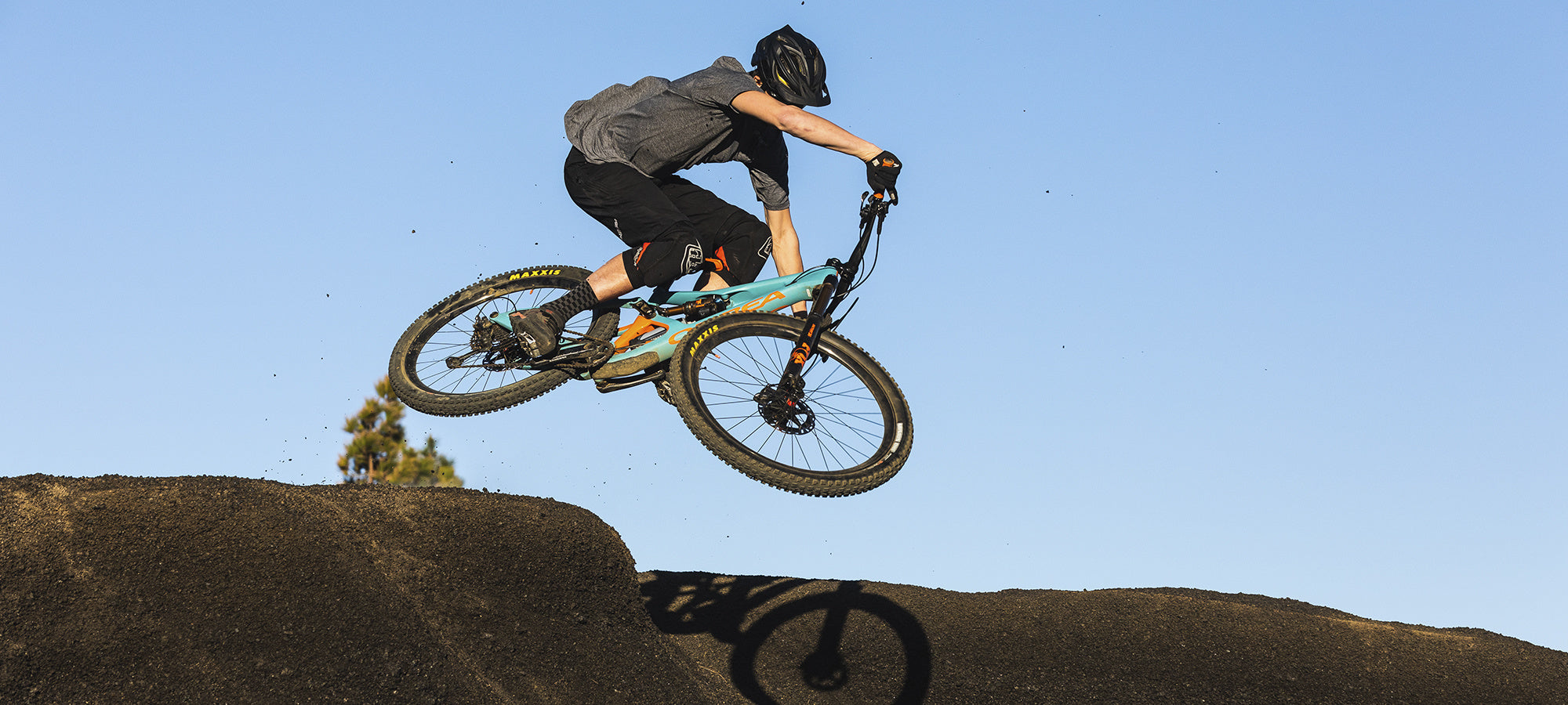 blue orbea trail bike jumping over a mountain top being ridden by man perfect for Wicklow trails