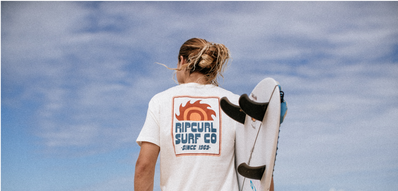 Man lying on beach in Rip Curl boardshorts