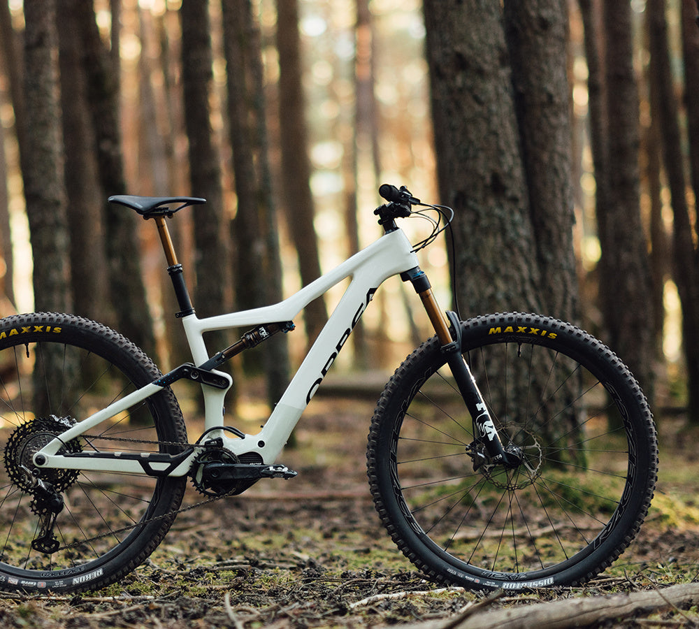 white orbea electric mountain bike in woodland setting