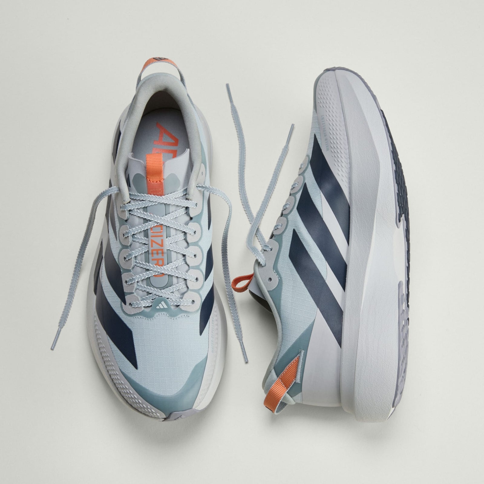 pair of adidas adizero evo sl all terrain running shoe in silver with orange details