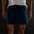 Man wearing Brooks Dash Reflective Shorts, showing how side panels glow in the dark