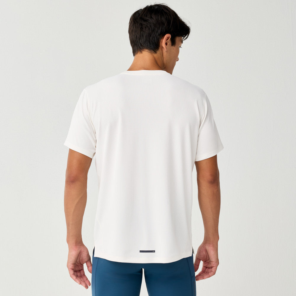 Man wearing Brooks Reflective Dash Tshirt in cream colour with reflective details on back