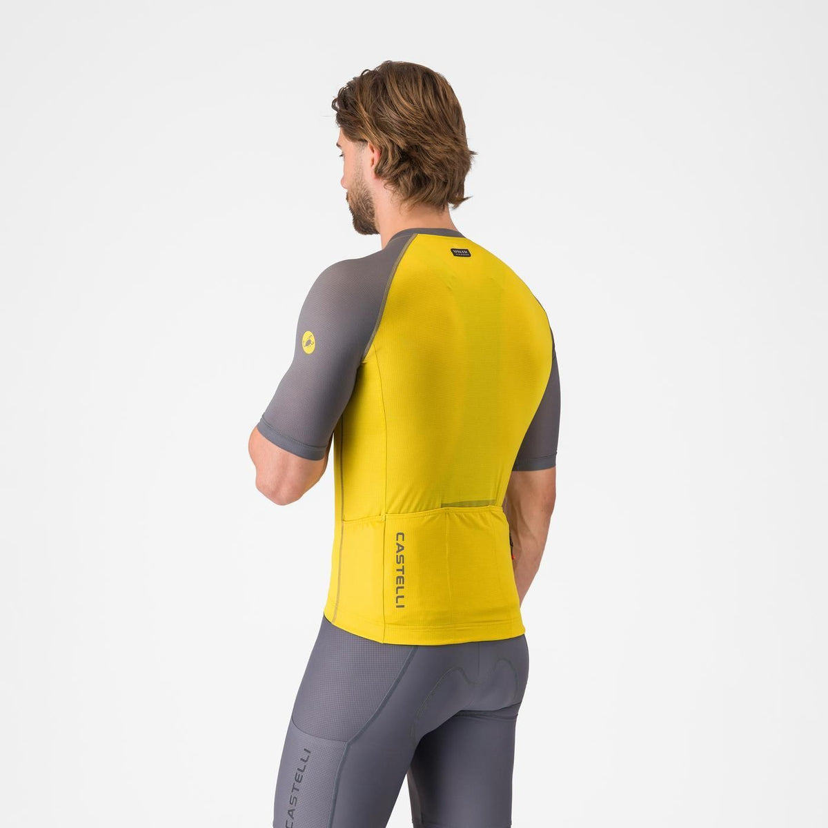 Man wearing Castelli Unlimited Endurance 3 Cycling Jersey in grey and yellow showing back pockets