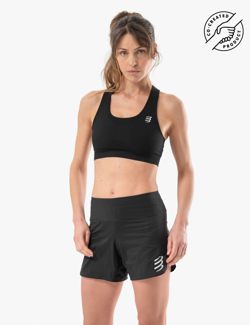 Woman wearing a black compressport sports bra and shorts with small logo in corner