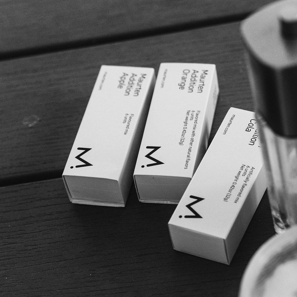 picture of maurten additions boxes with orange, cola and apple flavours. Flavour addition to water or drink mix.