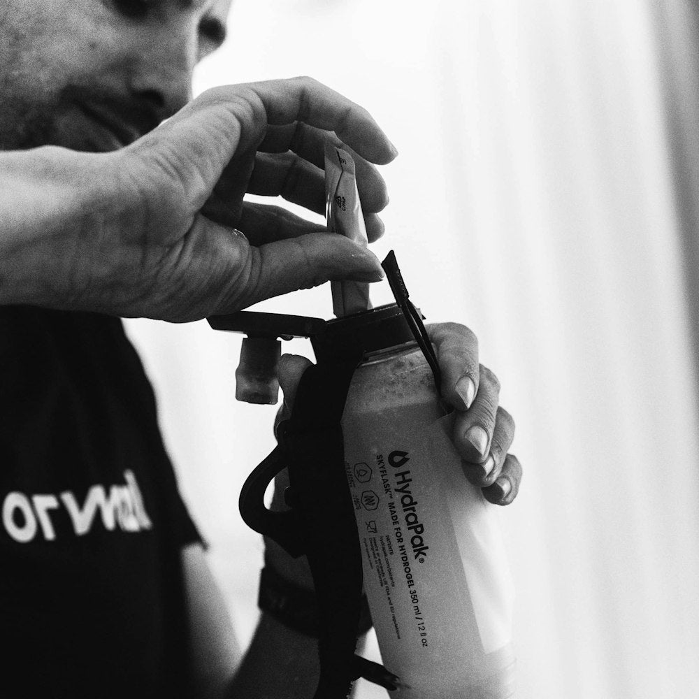 man pouring maurten additions into bottle 