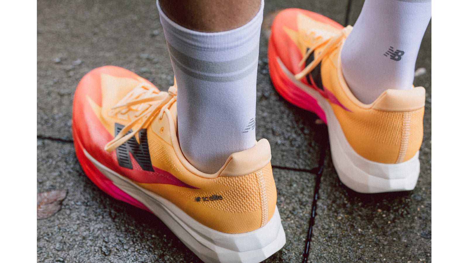 Man wearing New Balance FuelCell SuperComp Elite V5 race day running shoe in tangerine colour
