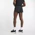 Person wearing black New Balance Men's RC Split Short 3"athletic back of shorts with a brand logo on a white background