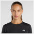 close up of woman wearing NB athletics long sleeve run top in black, showing reflective NB logo