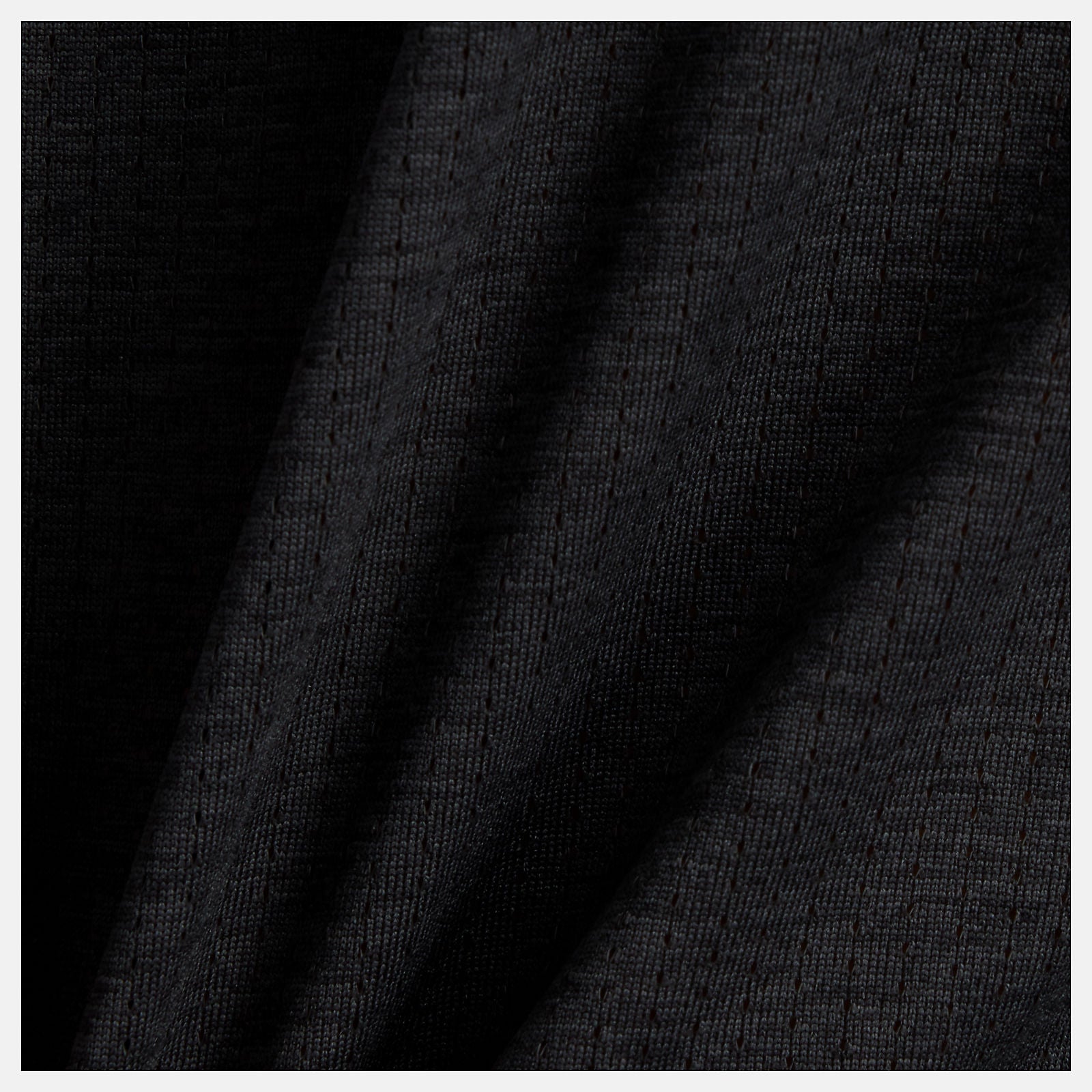NB athletics long sleeve run top in black, close up of fabric with pin dot mesh