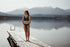 woman standing by lake wearing an orca bikini