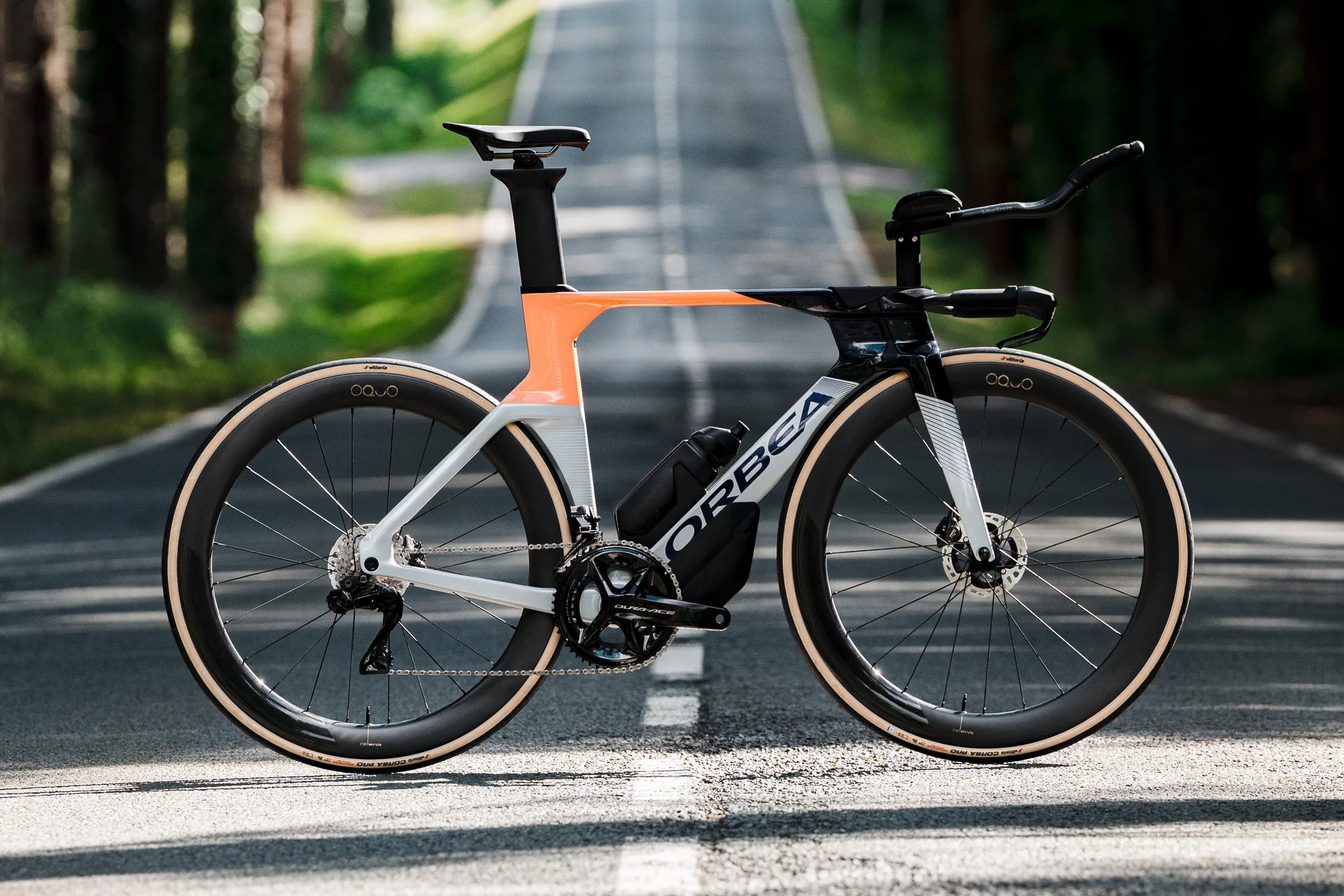 orbea ordu triathlon bike in orange and teal, on a road