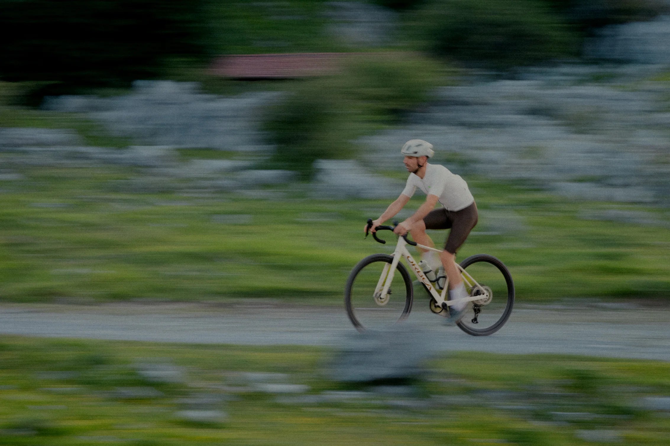 Man riding an Orbea Terra H on a gravel path, blurred background