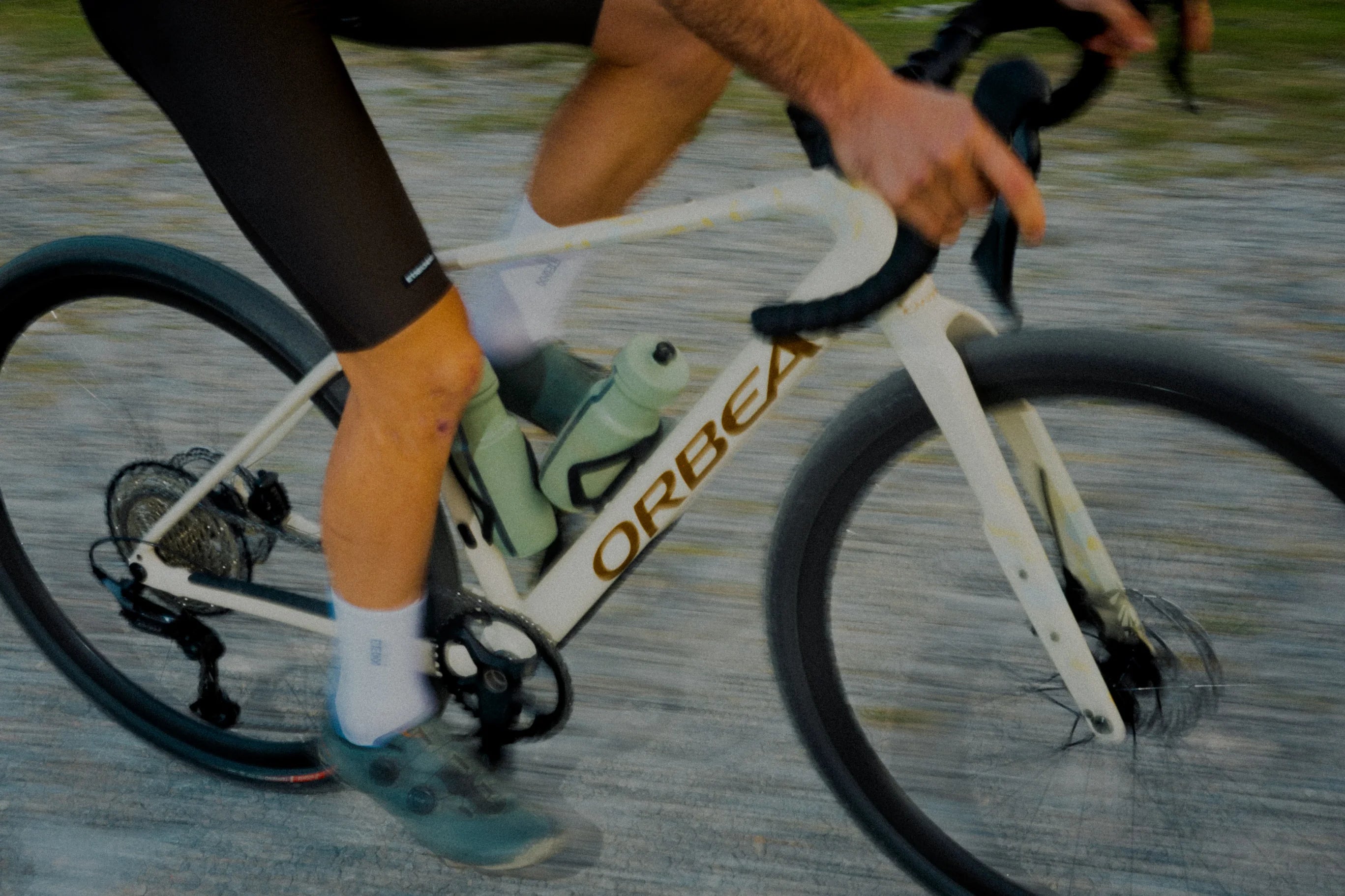 Close up of a man riding an Orbea Terra H with bottles mounted on the frame