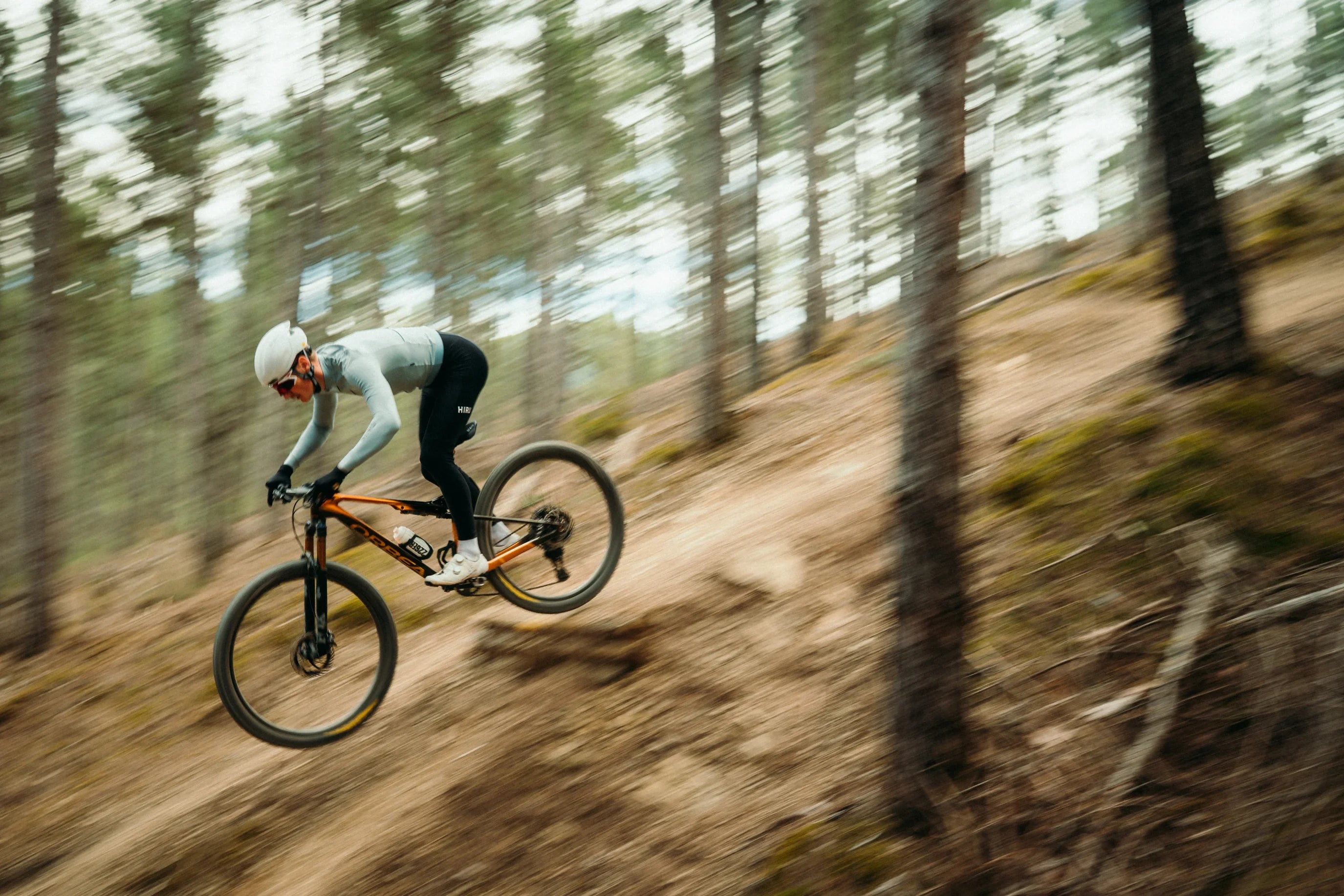 man riding the orbea oiz mountain bike in the forest