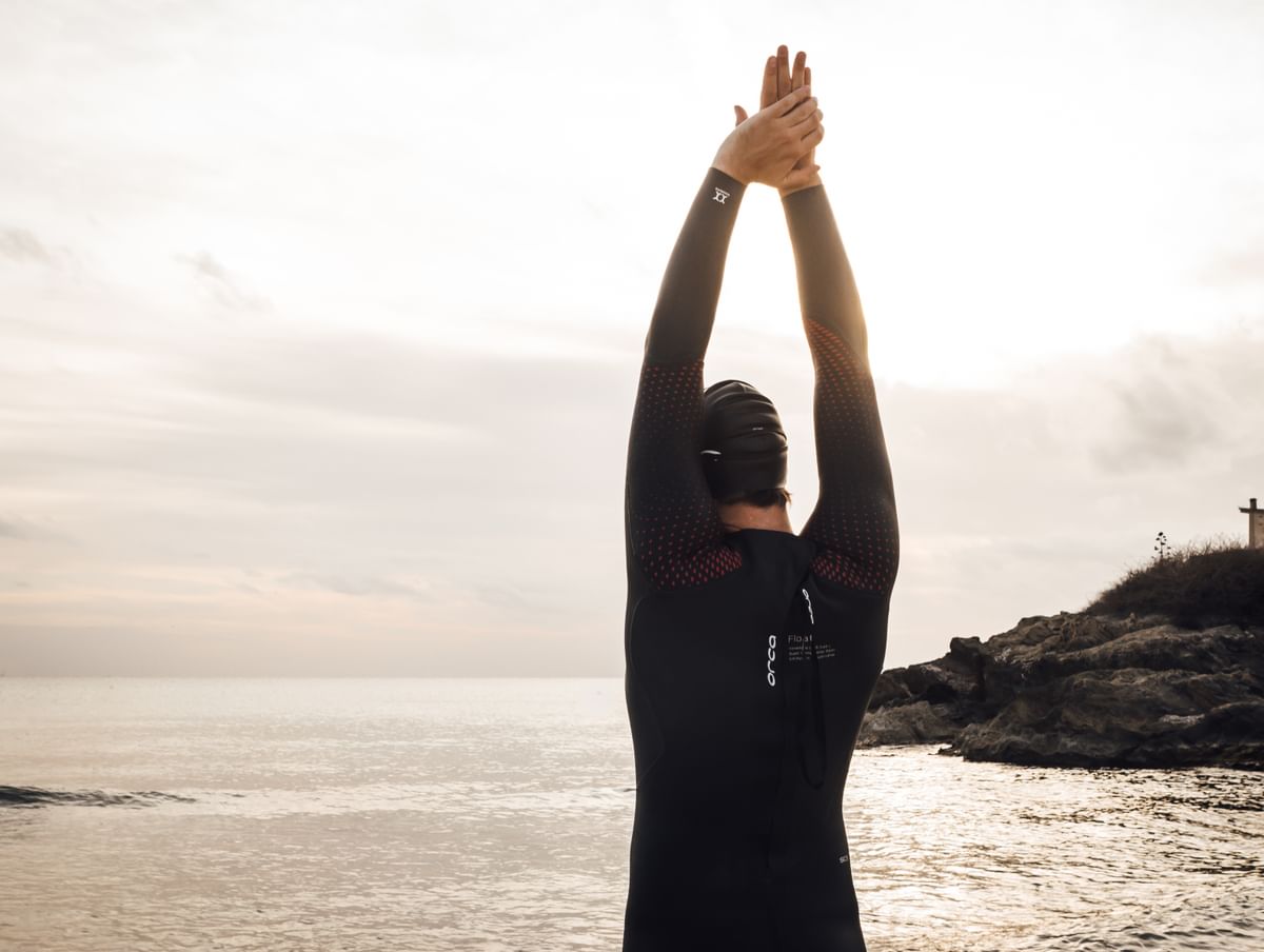 man stretching before a sea swim in the orca athlex float triathlon wetsuit