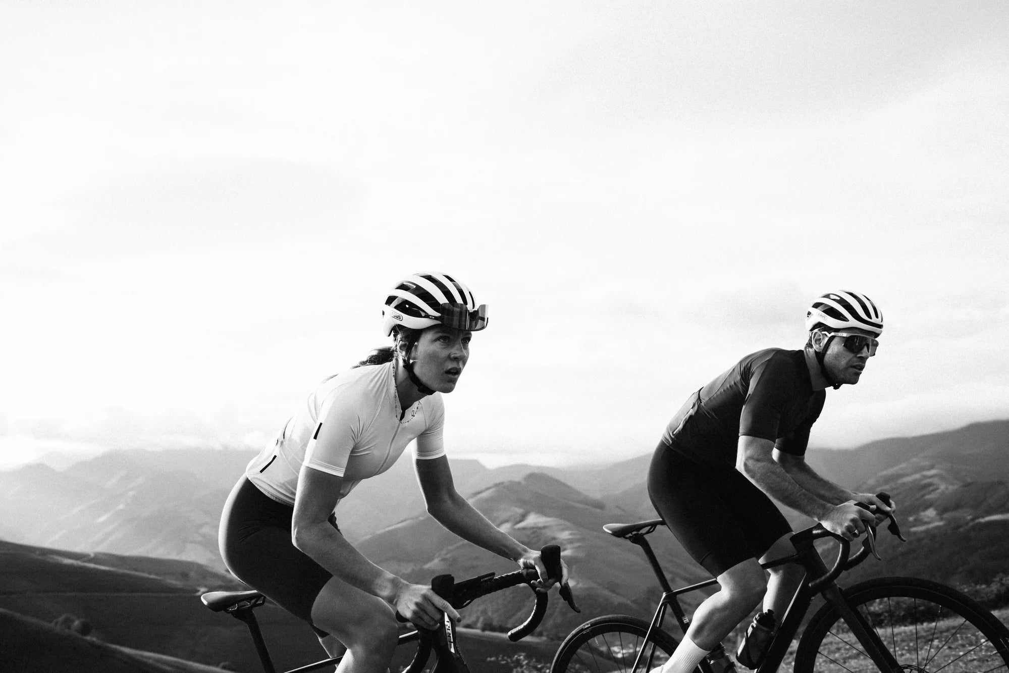 man and woman cycling Orbea road bikes over mountain roads