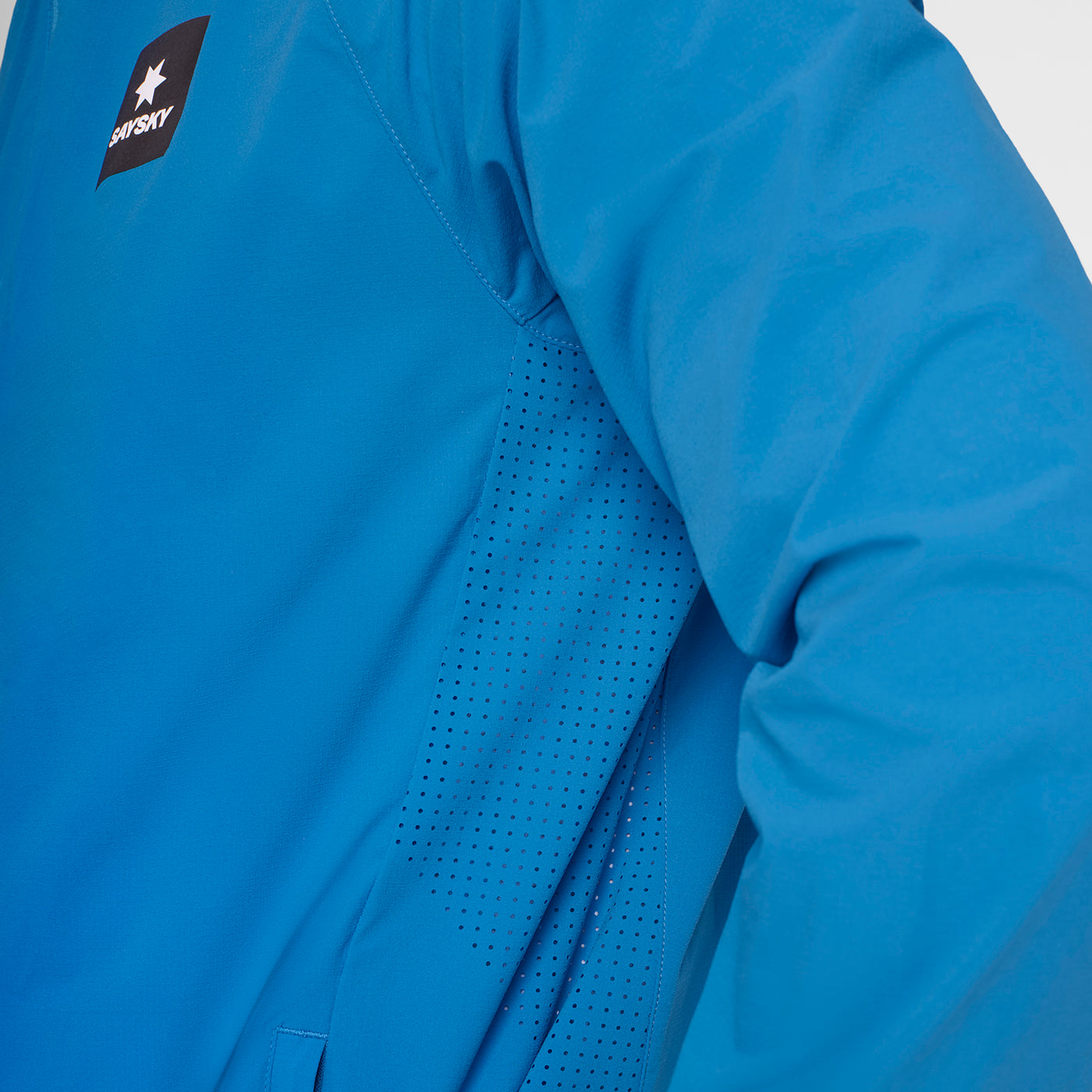 Man wearing SAYSKY Clean Pace Flex Hooded Running Jacket in blue, showing ventilated sides