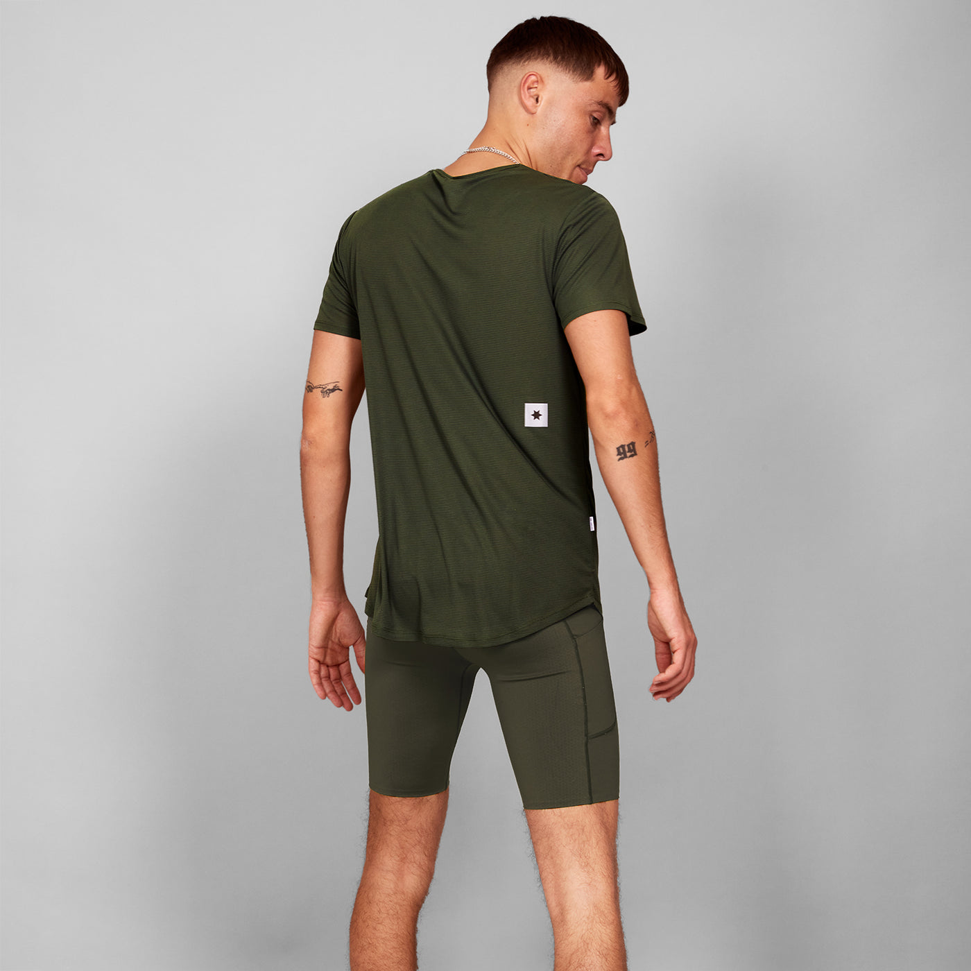 man wearing SAYSKY combat 9 inch run shorts in green with SAYSKY run tee