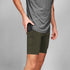 man wearing SAYSKY combat 9 inch run shorts in green, showing phone pocket on leg