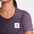 Woman wearing SAYSKY reactive women's run tee, purple colour,  showing hidden pattern when wet
