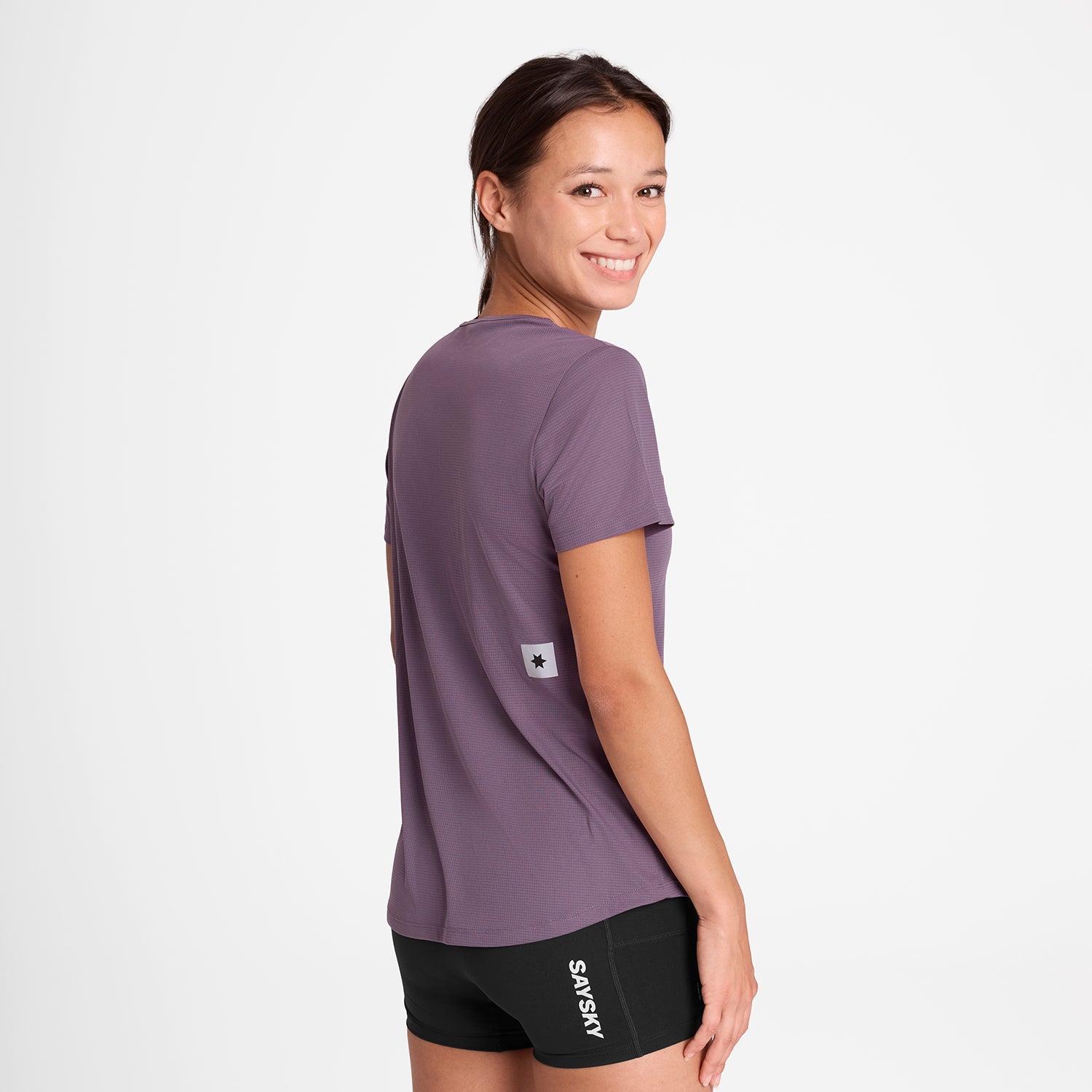 Woman wearing SAYSKY reactive women's run tee, purple colour, with saysky star logo in small on back
