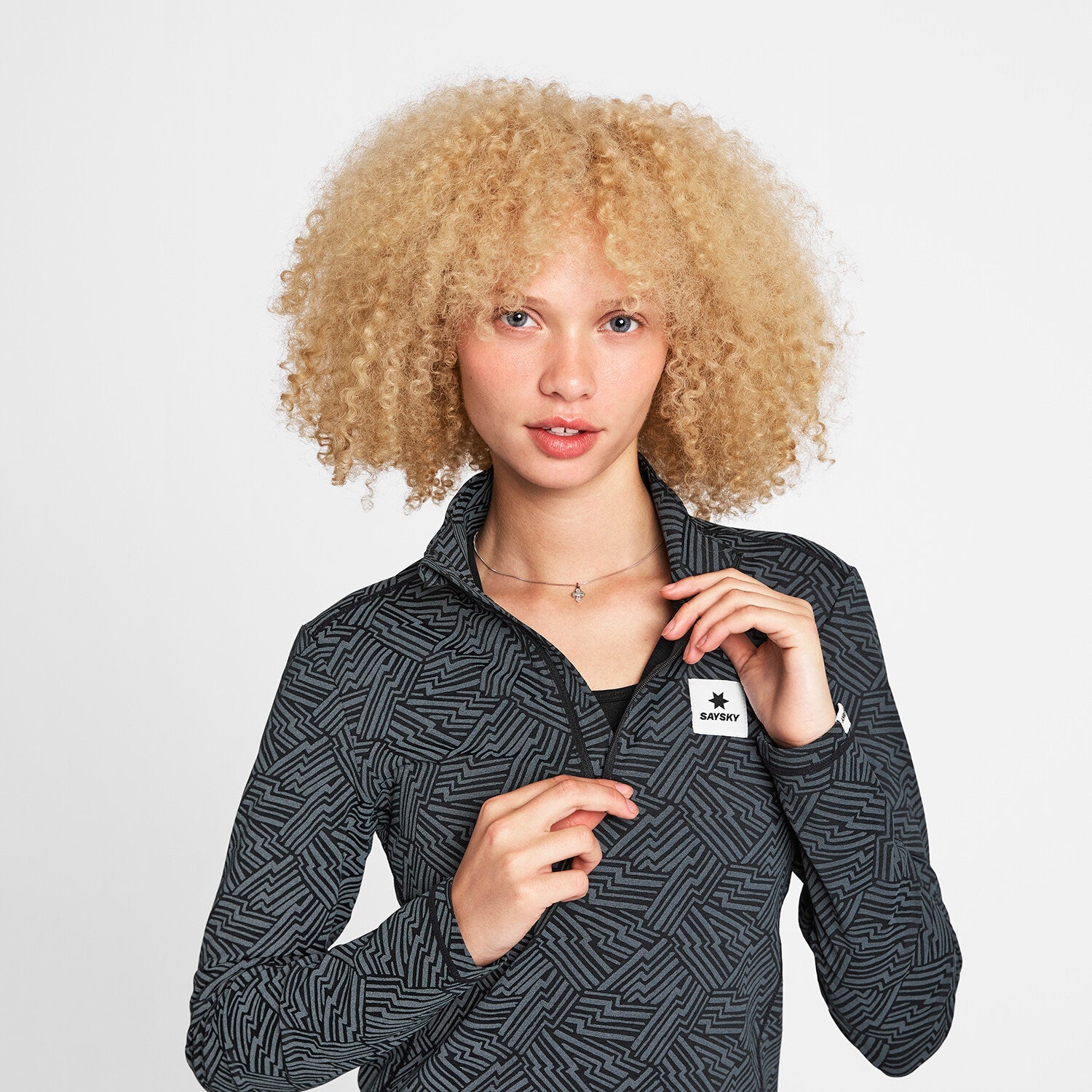 Woman wearing SAYSKY Reflective Pace Half Zip Long Sleeve Run Top showing zip
