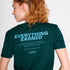 Woman wearing a green SAYSKY running t-shirt with 'EVERYTHING EARNED' text on the back