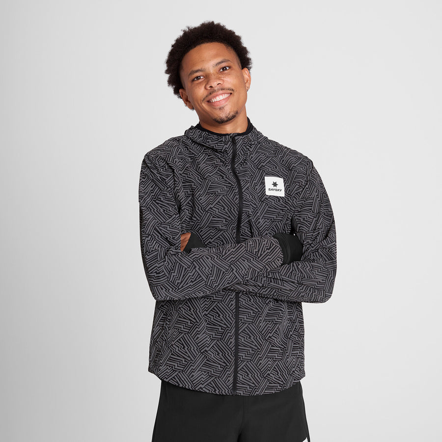 saysky reflective blaze jacket for men, warm wind proof jacket for running in cold dark conditions, black with grey reflective geometric pattern, man wearing saysky jacket with arms crossed