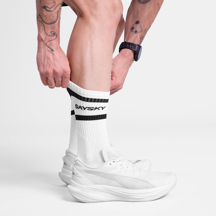 SAYSKY unisex running socks, cushioned and breathable sock for running white black socks, image of person wearing SAYSKY socks with white runners