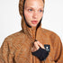 Woman wearing SAYSKY reflective blaze jacket in orange colour, with hood up