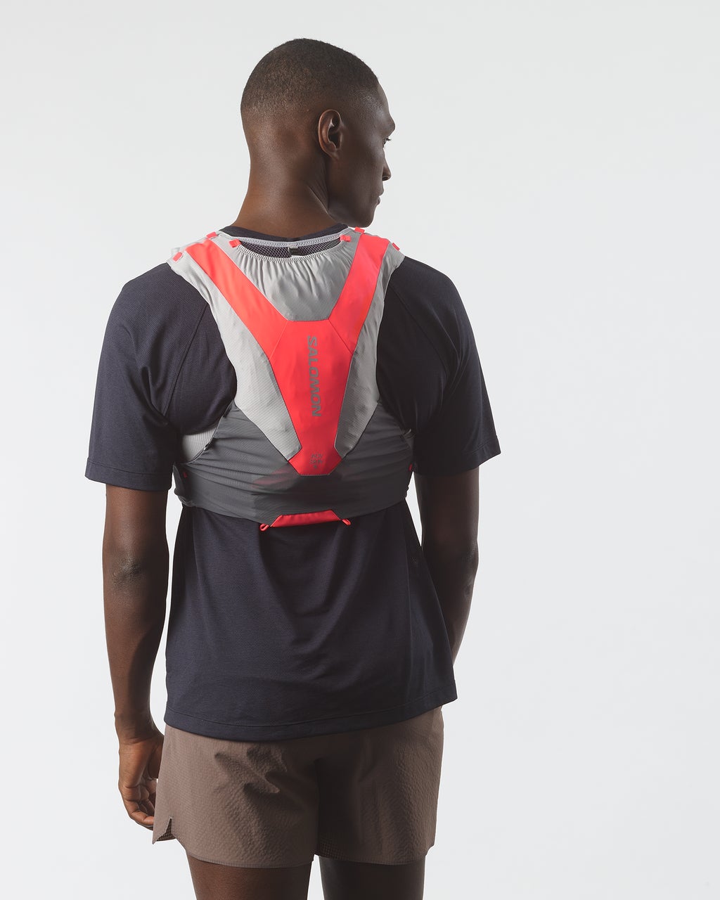 Man wearing Salomon ADV Skin 5 hydration vest, with flasks, castelrock colour