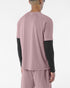 Man wearing salomon shakeout core tee in a pink colour, reflective logo on back