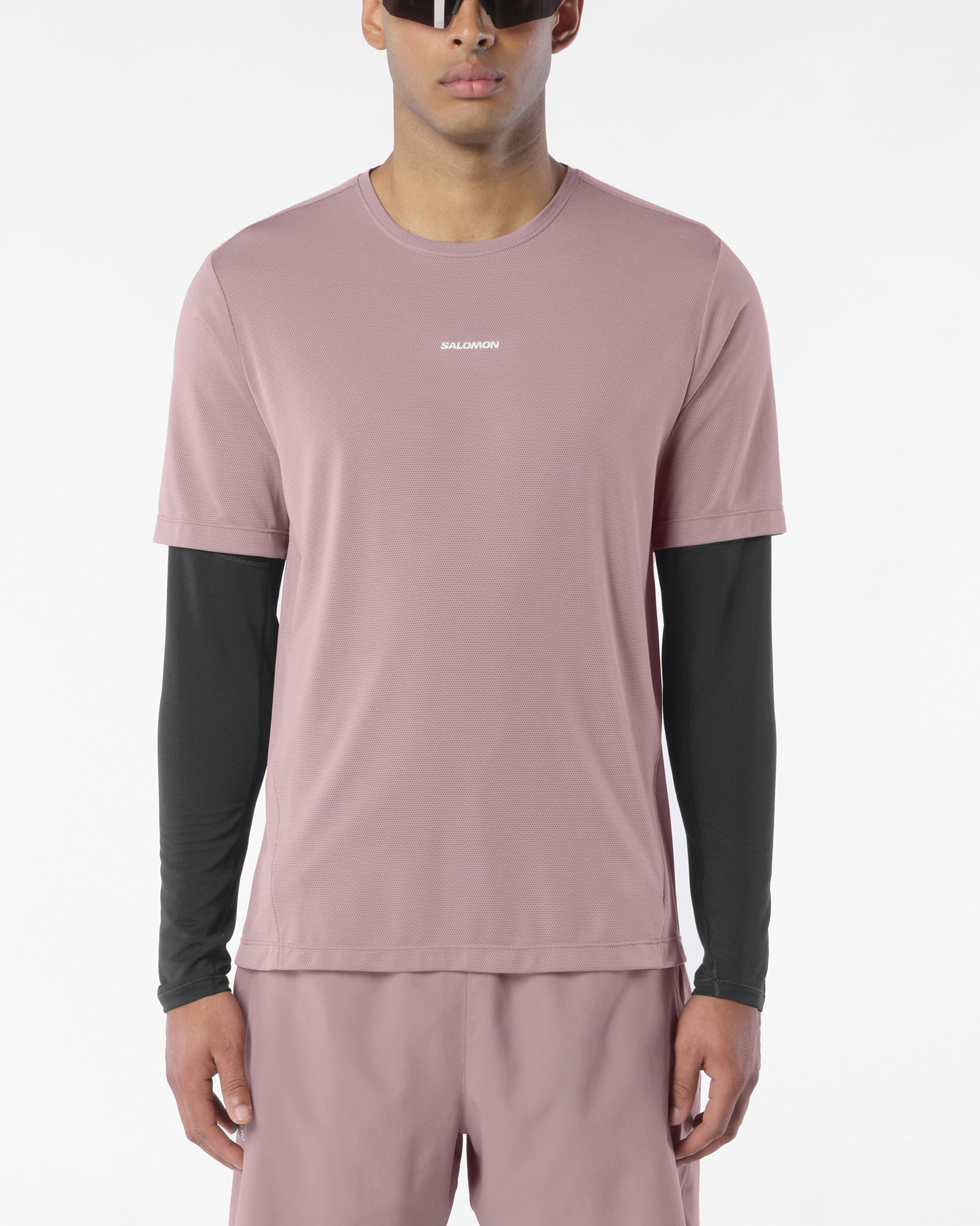 Man wearing salomon shakeout core tee in a pink colour, reflective logo on front