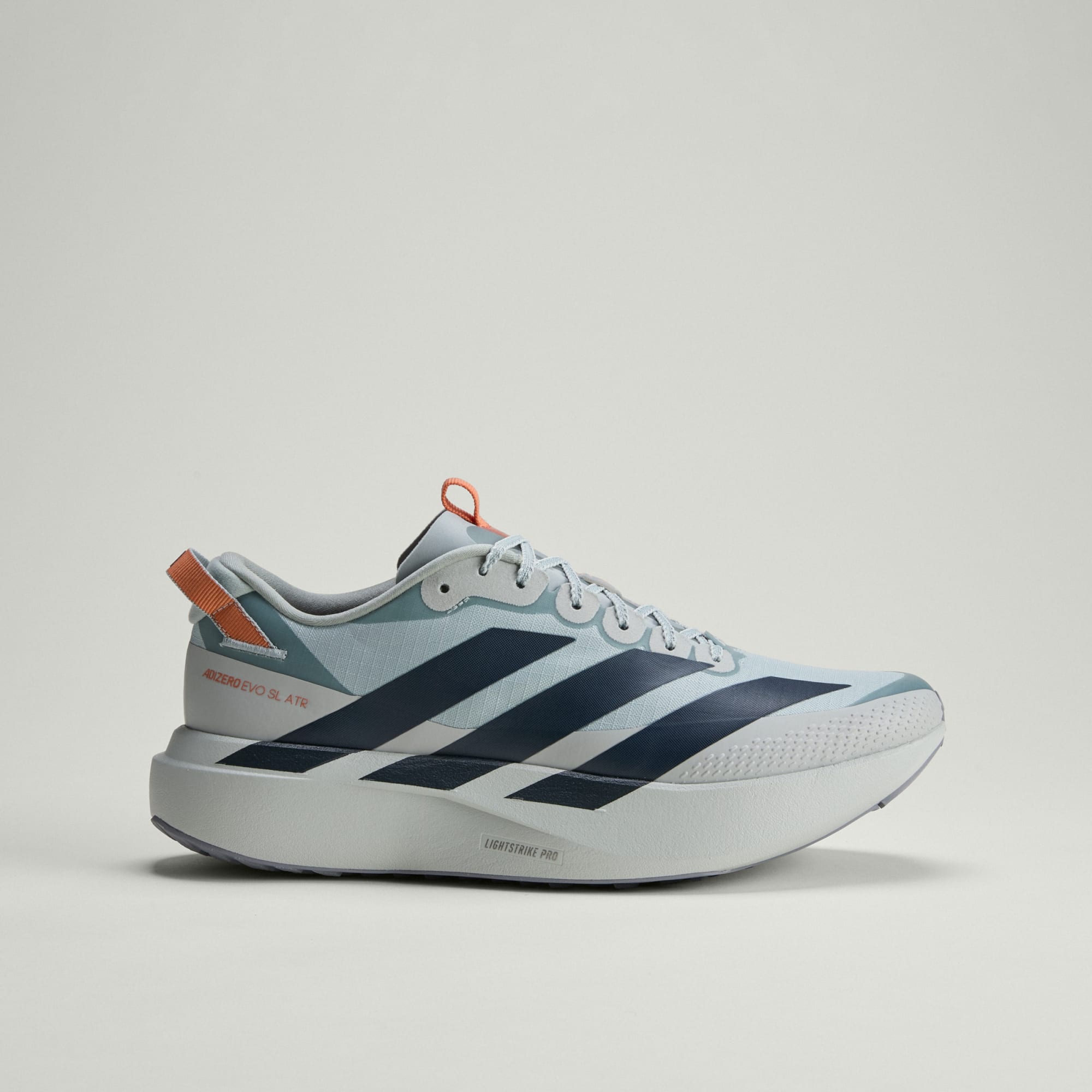 side view of adidas adizero evo sl all terrain run shoe in silver with black stripes and orange trim