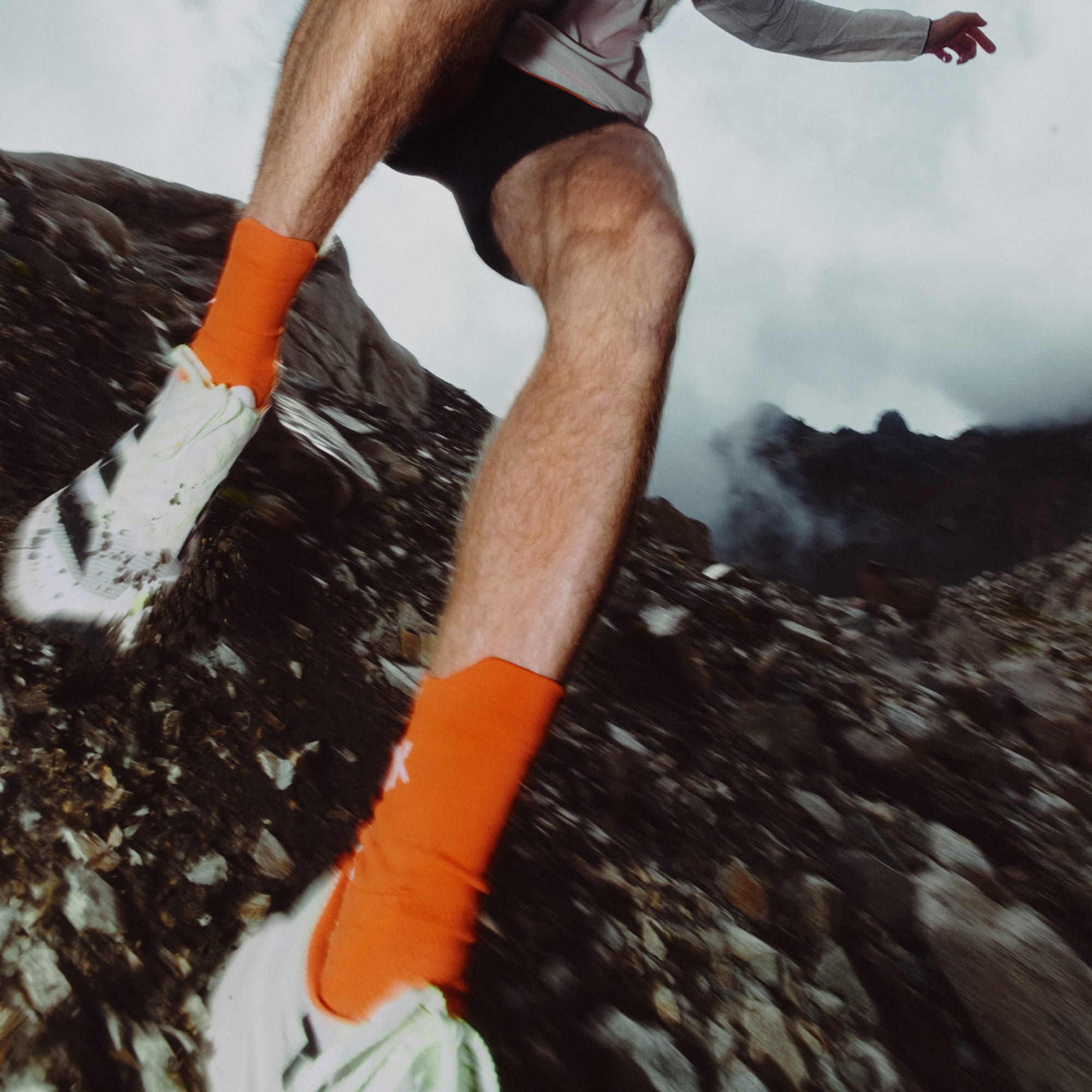 man running on rocky terrain in the adidas terrex agravic tt trail running shoe