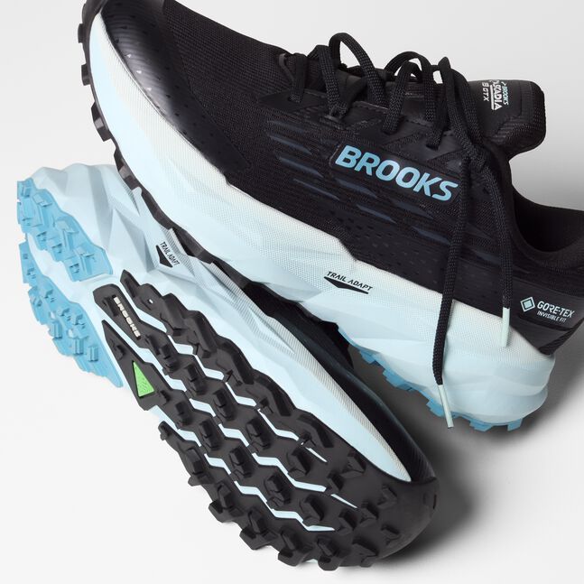 Brooks cascadia 19 GTX, waterproof trail running and walking shoe, black shoe upper with light blue sole, pair of shoes stacked on top of each other showing profile and sole of shoe