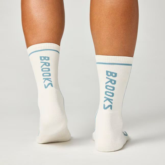 back view of brooks cascadia crew trail running socks in a white colour with blue brooks branding
