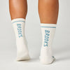 back view of brooks cascadia crew trail running socks in a white colour with blue brooks branding