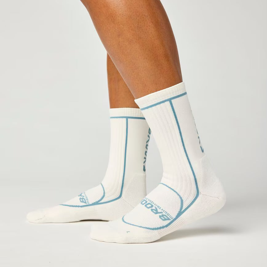 side view of brooks cascadia crew trail running socks in a white colour with blue brooks branding