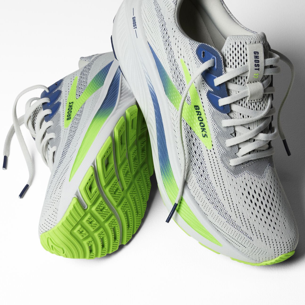 brooks ghost 17 for men road running shoe for everyday training white colour with white sole and blue and green details view of both shoes on each other